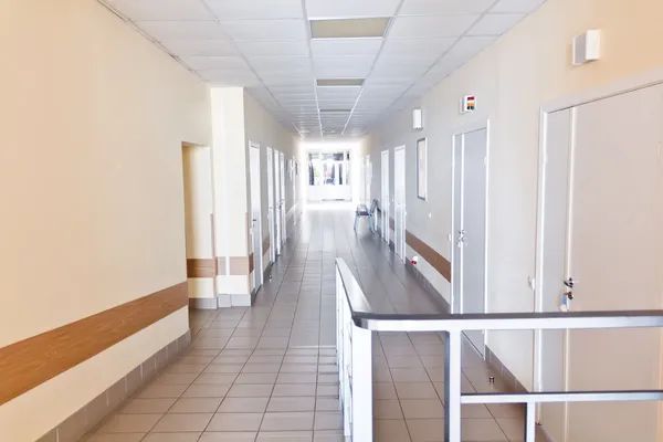 Medical facility hallway with patient rooms and clinical service area.