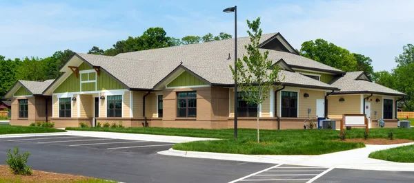 Single-story assisted living facility with accessible entrance and parking area.