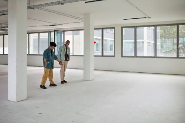 General contractor consulting with clients about commercial office space renovation planning.