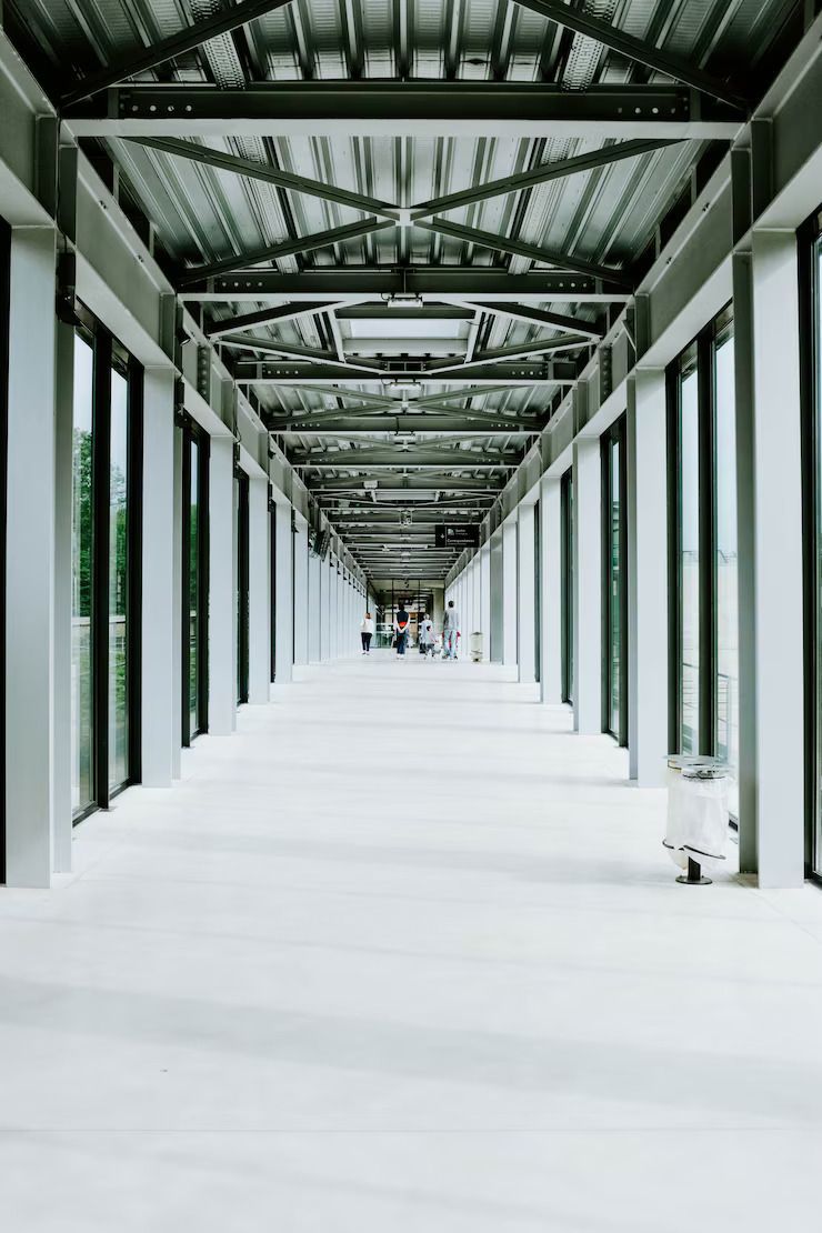 Modern white corridor with seamless epoxy flooring and exposed steel ceiling structure