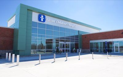 Akron Children's Hospital entrance with glass facade, blue sign, and brick walls.