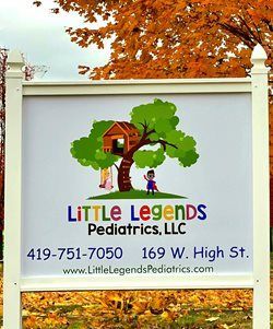 A sign for Little Legends Pediatrics, LLC, at 169 W. High St., featuring a treehouse logo and contact information.