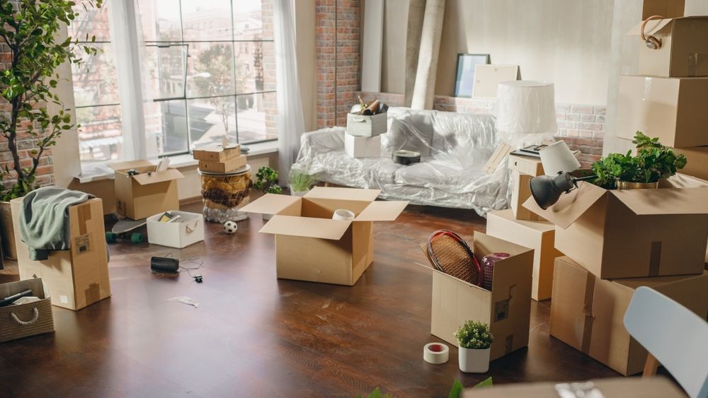 Packing up to move out of an apartment. Boxes of things in a living room.