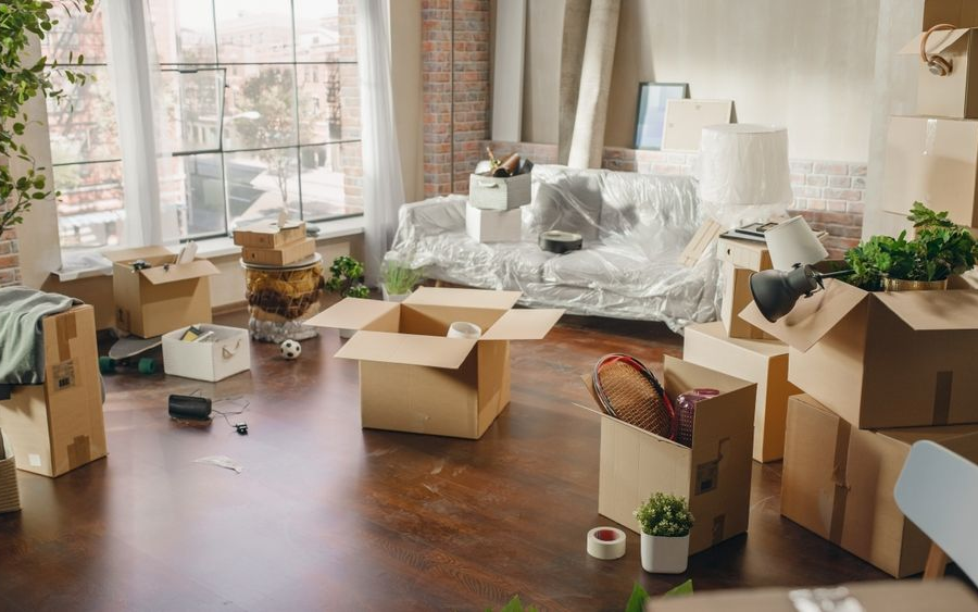Packing up to move out of an apartment. Boxes of things in a living room.
