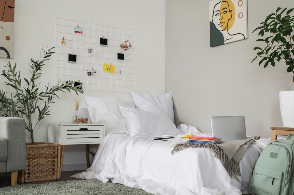 Laptop with copybooks on bed in student's room