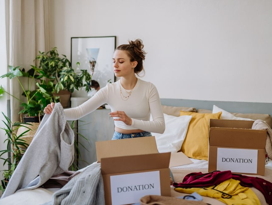 Young woman donating items to declutter her apartment.