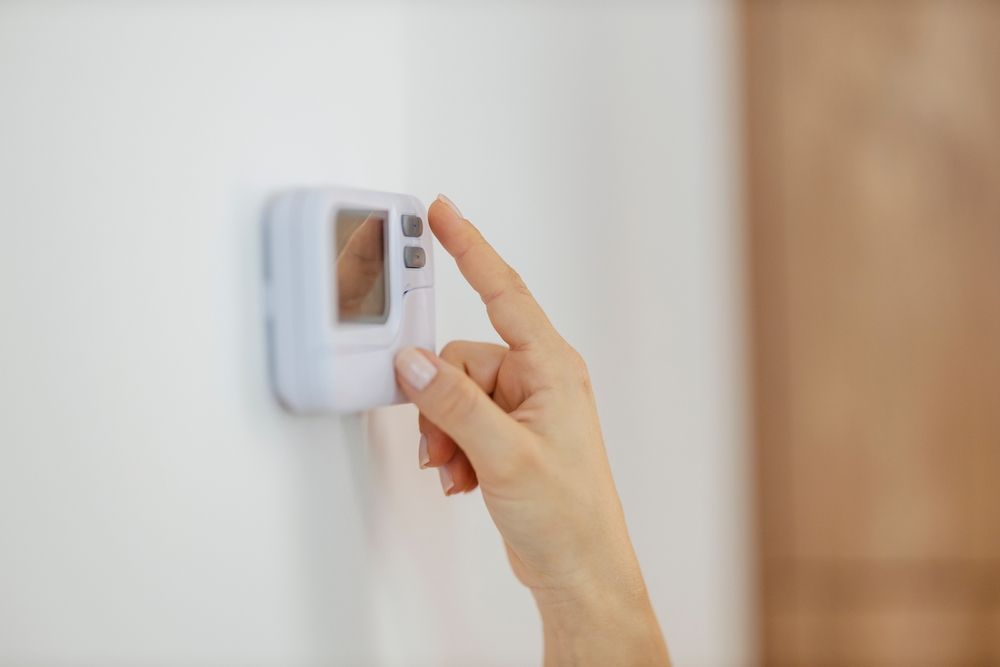 Someone is adjusting the thermostat in an apartment.