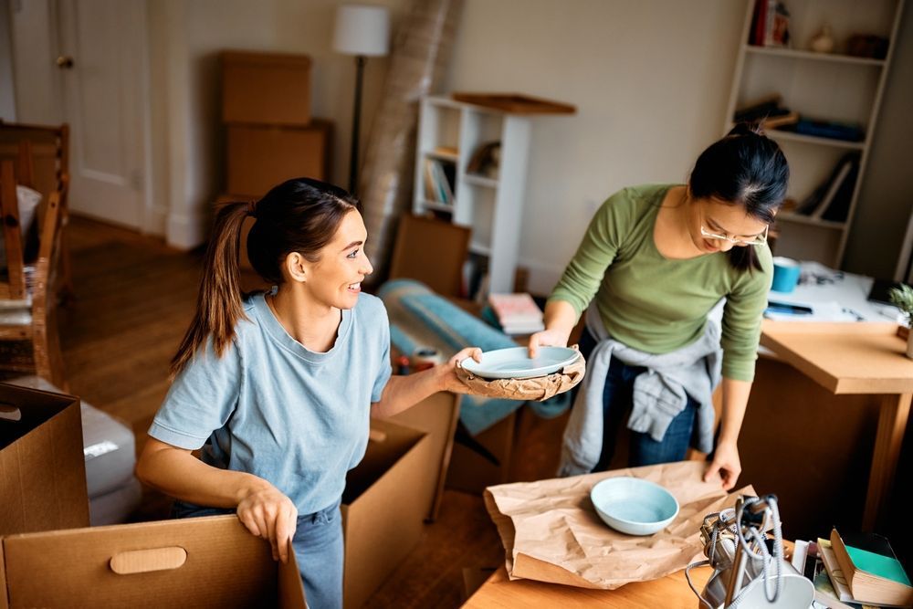 woman and her friend unwrapping fragile things