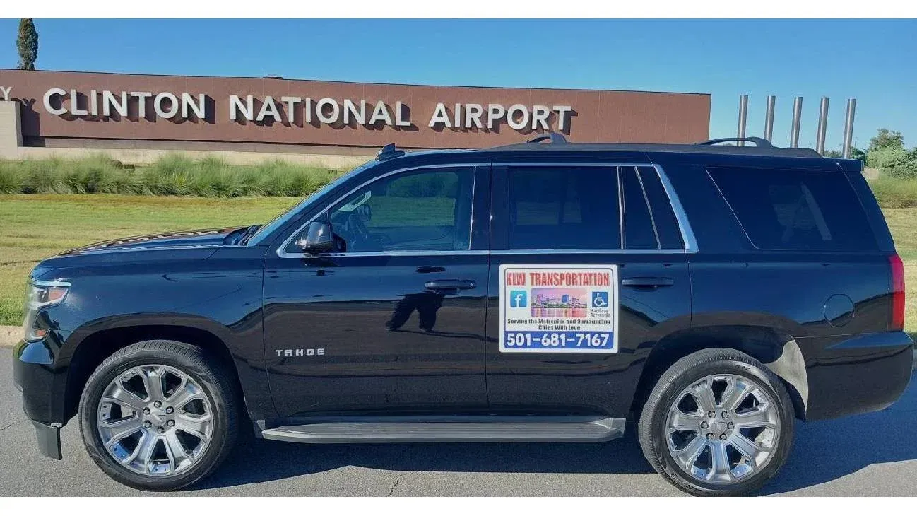 Black SUV parked in front of Clinton National Airport, with logo on the side.