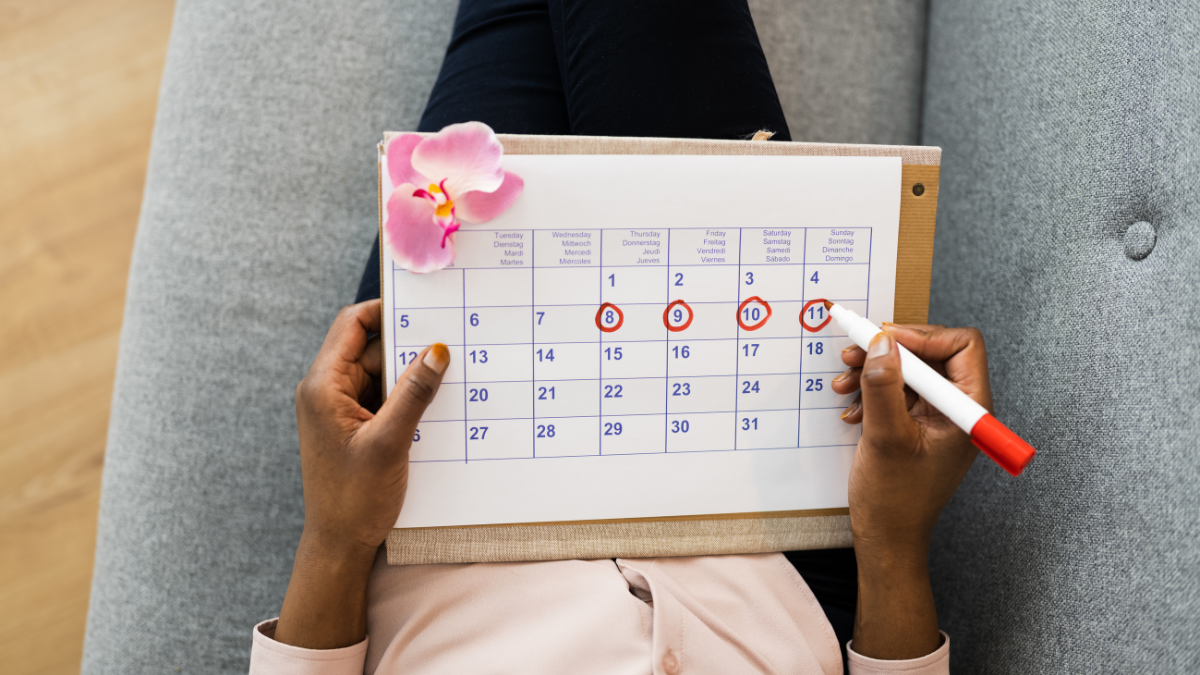 Woman holding a calendar and circling dates on it