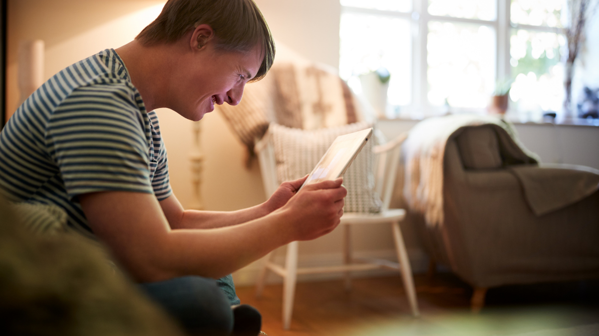 Man with disability holding a tablet and smiling