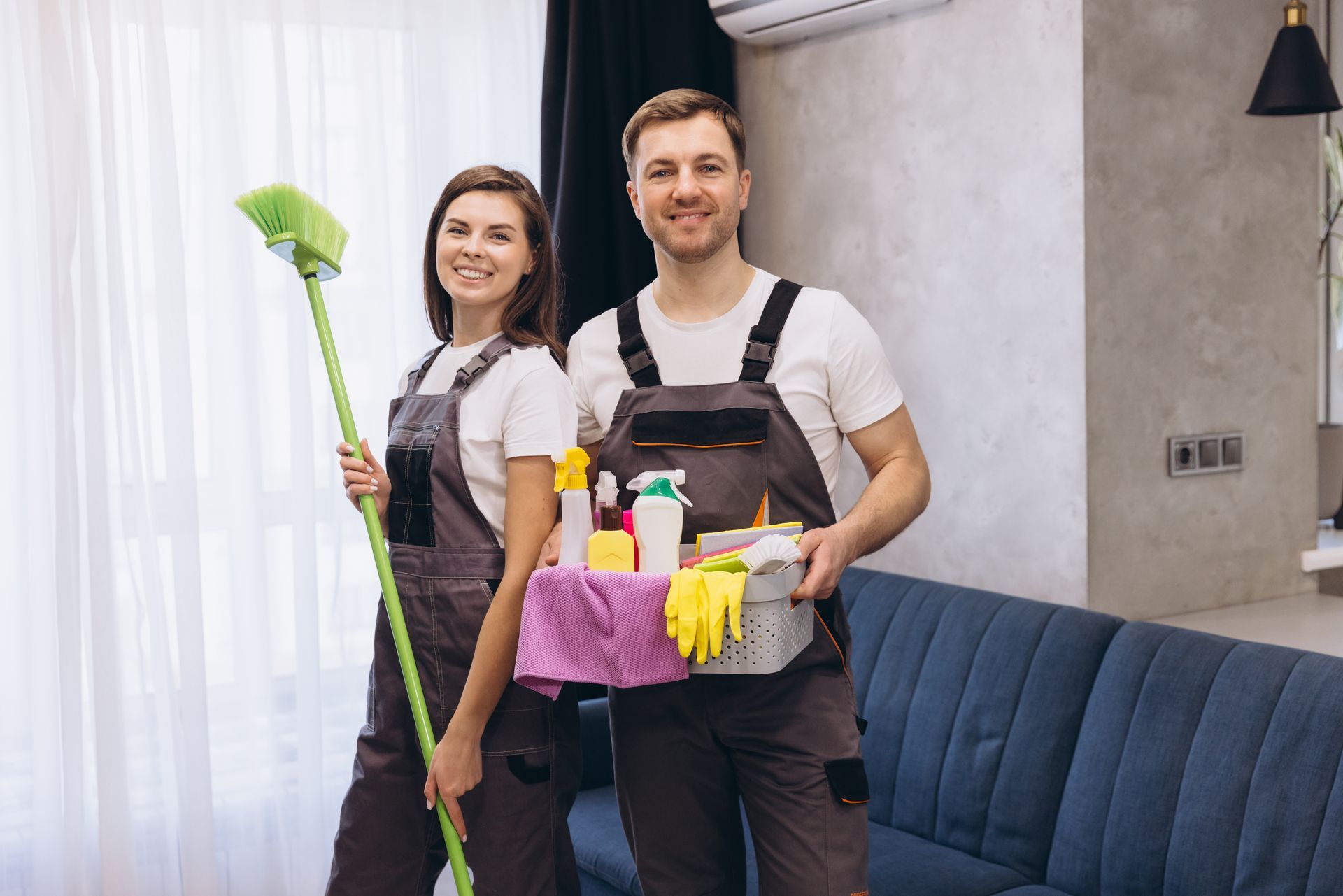 Two cleaners with mops, buckets, and supplies standing in a modern living room