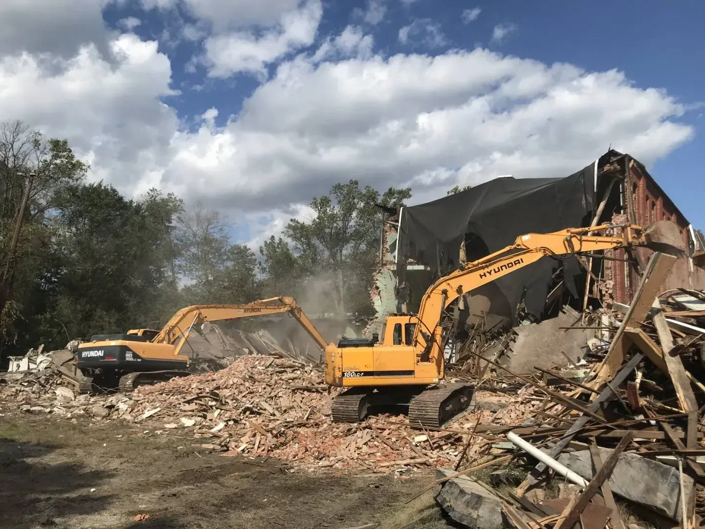 Two excavators demolishing a commercial building in Conroe, Texas.