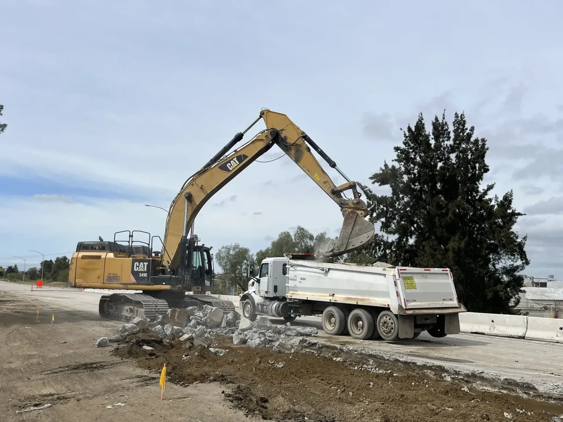 An excavator performing concrete debris removing services in Conroe, TX.
