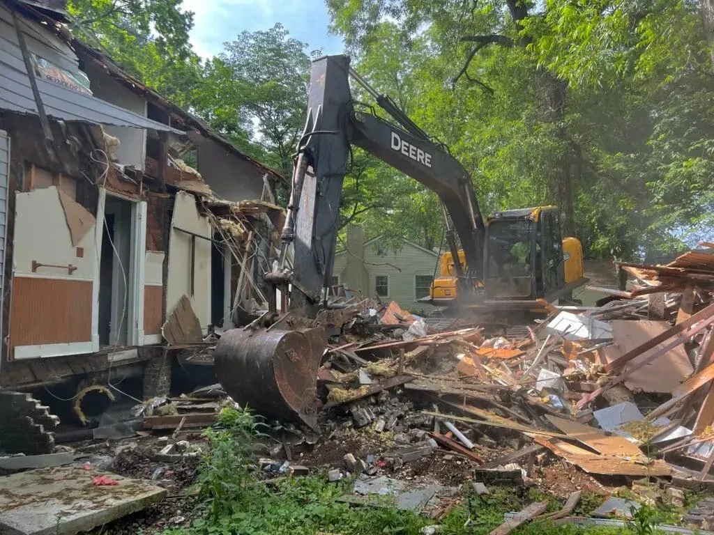 An excavator demolishing a rural home in Montgomery County, Texas.