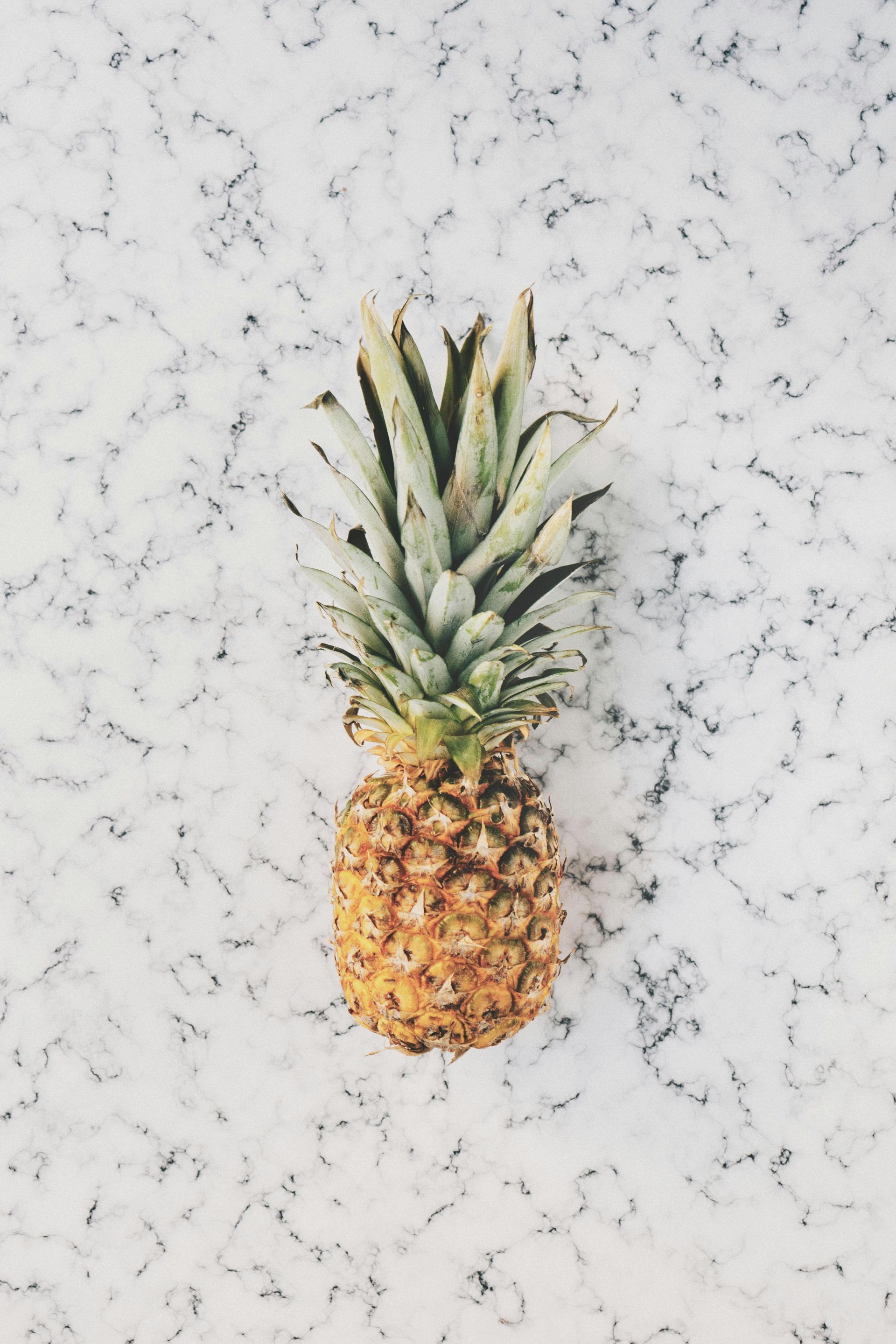 Piña sobre una superficie de mármol blanco.