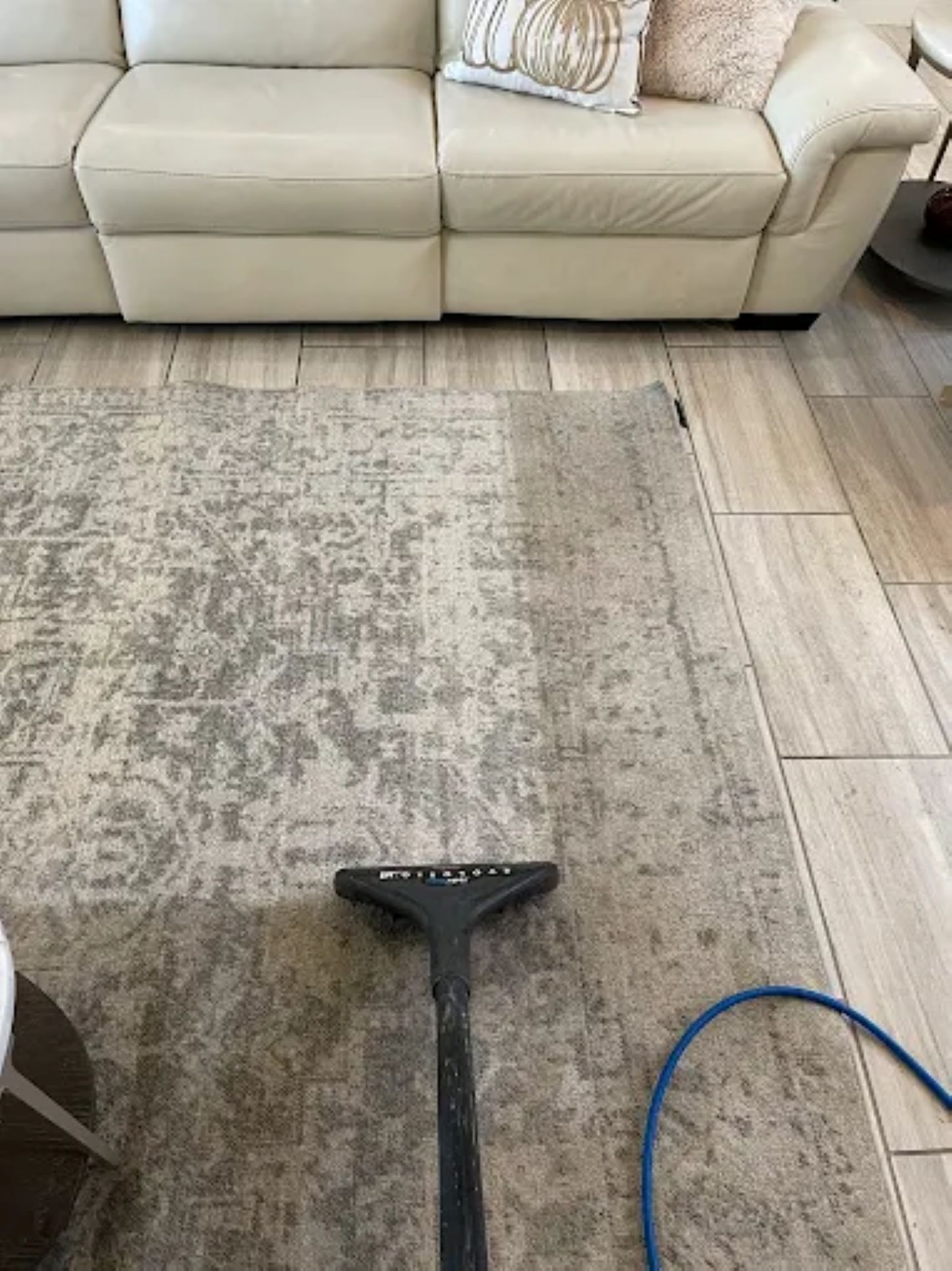 a rug is being cleaned with a vacuum cleaner .