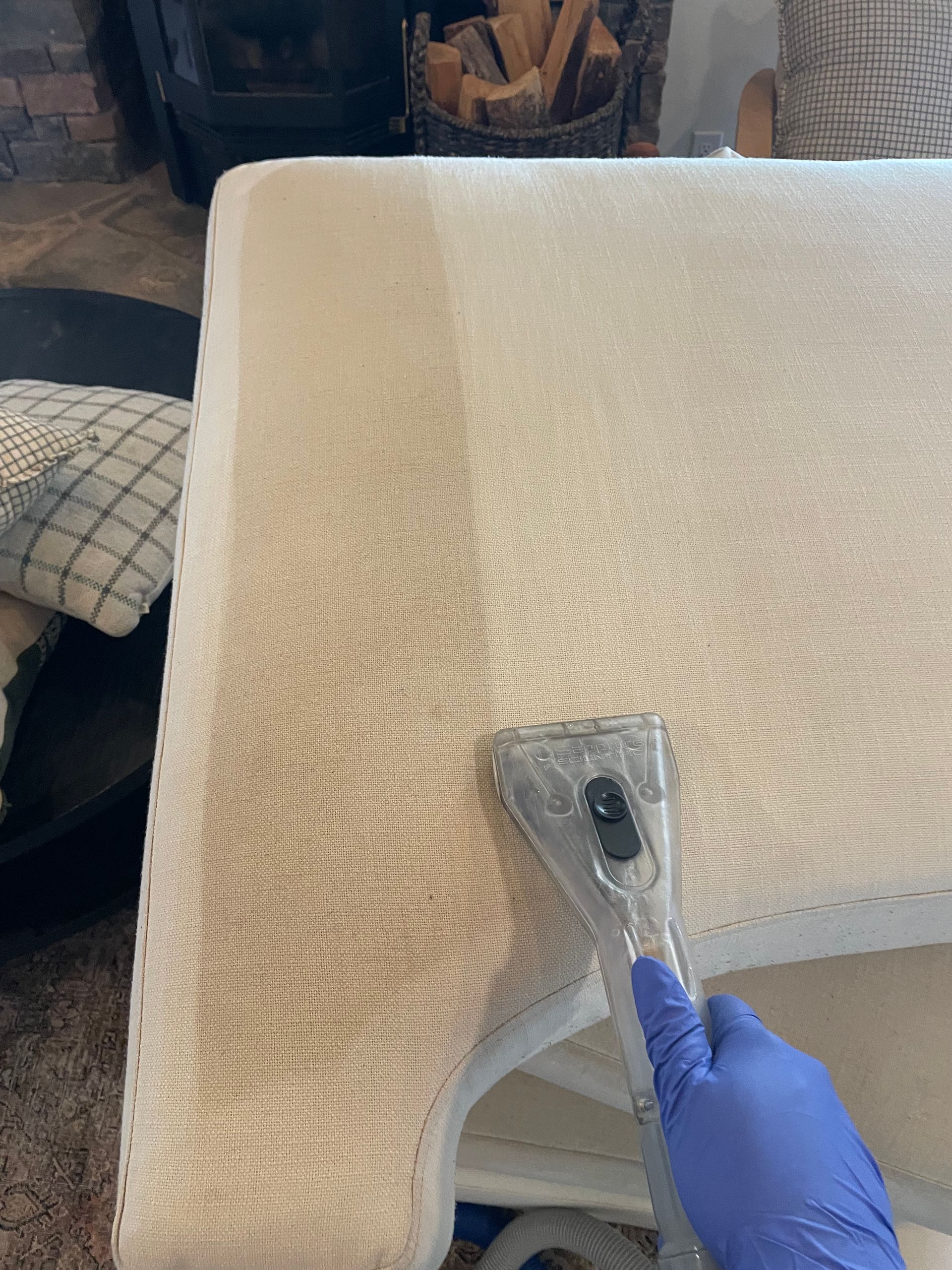 a person is cleaning a couch with a vacuum cleaner