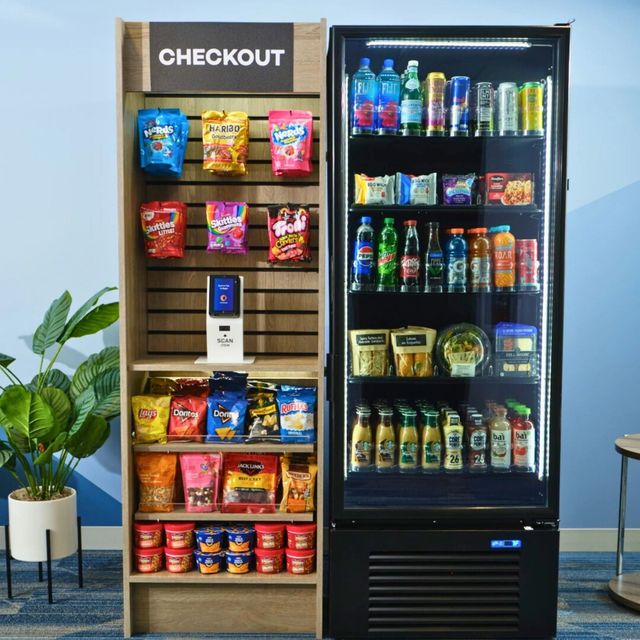 Checkout snack display with chips, candy, and drinks beside a refrigerated beverage case