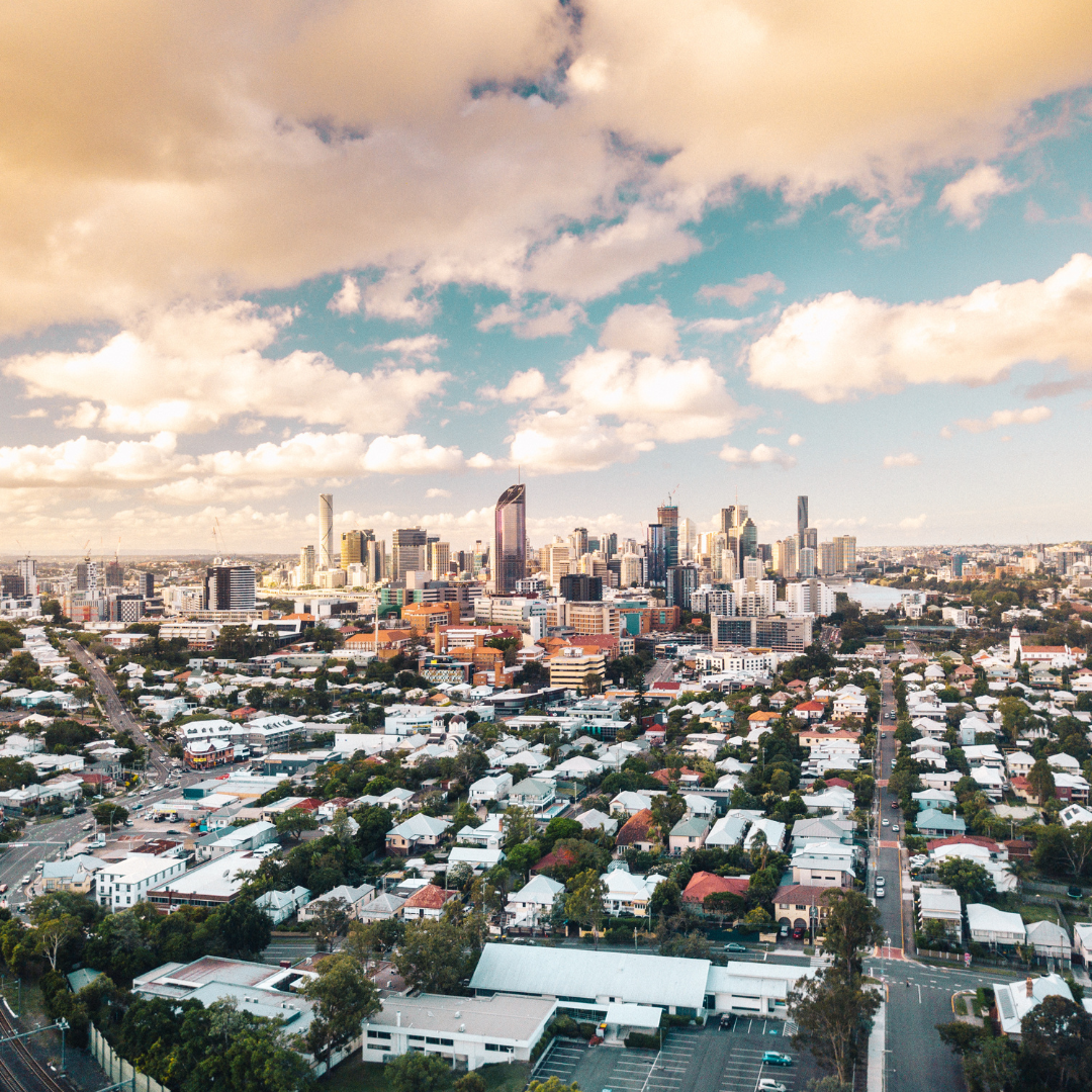Aerial view of Brisbane, Australia, with buildings and skyline under a cloudy sky.