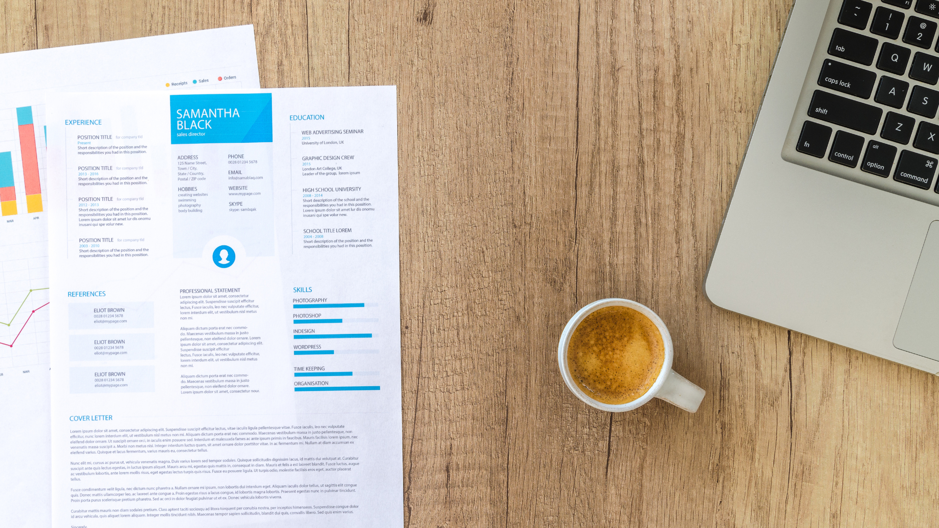 Resume and chart on wooden desk with coffee cup and laptop.