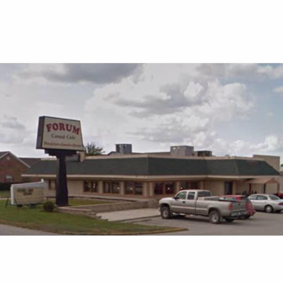 Forum Loan Center storefront with parked pickup truck and cloudy sky