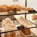 Bakery display with muffins, frosted pastries, and cakes on tiered shelves