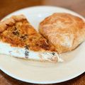 Two slices of pie on a white plate, one browned and one dusted with powdered sugar