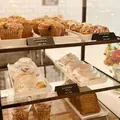 Bakery display with muffins, frosted pastries, and cakes on tiered shelves