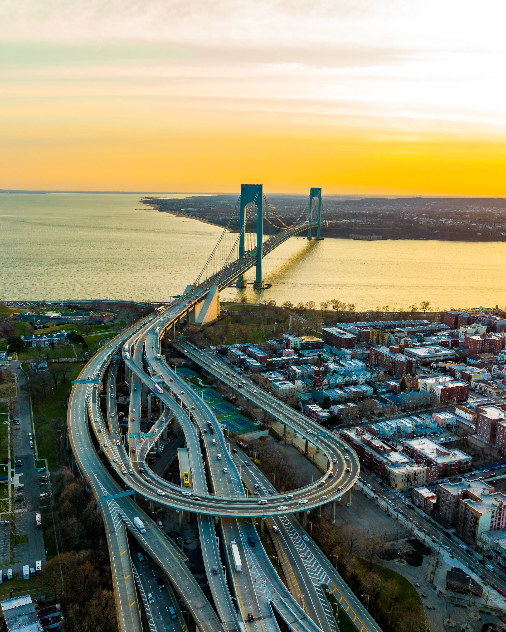 A car is driving down a highway at sunset.