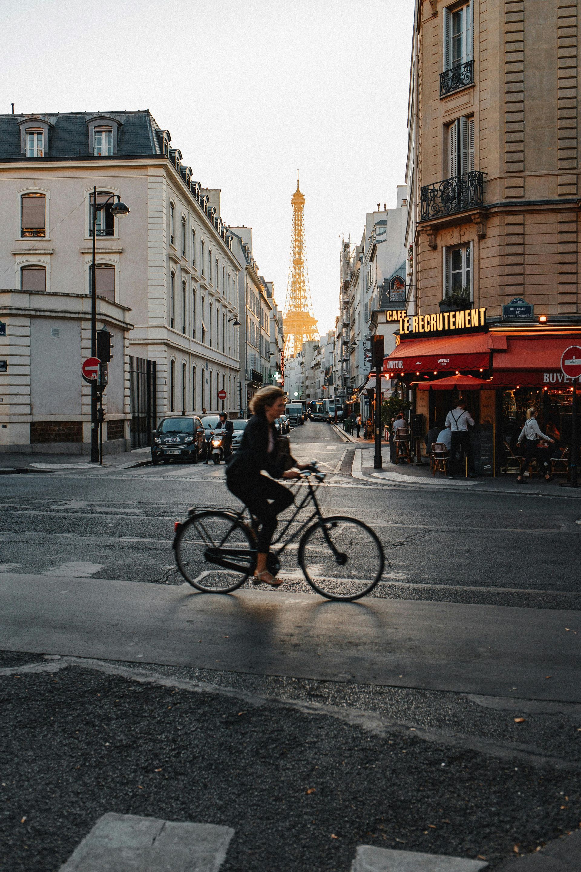 A woman is riding a bike down a city street.