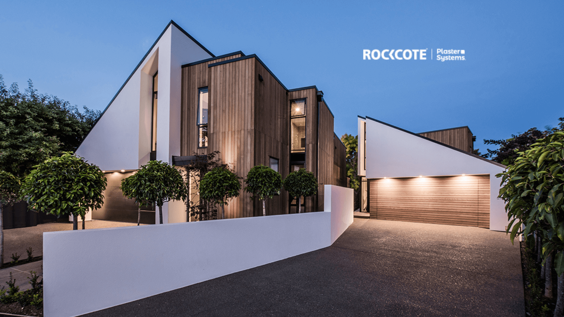 A modern house with a garage and trees in front of it