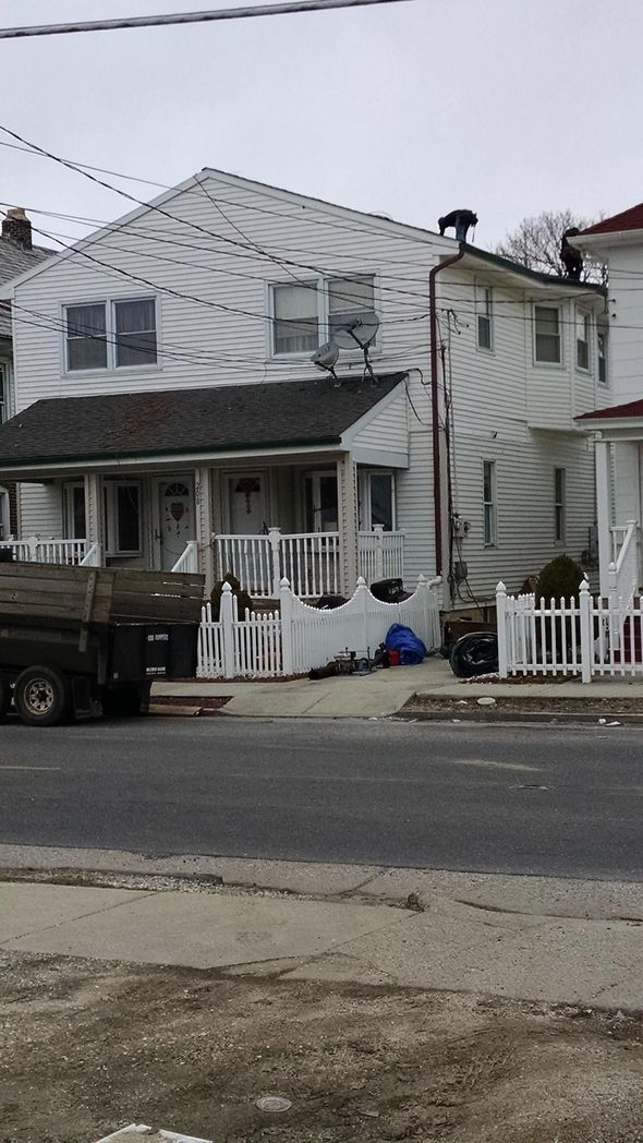 White two-story house with a porch and white picket fence in front. A truck is parked to the left.
