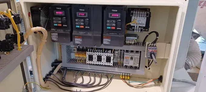 Electrical control panel with three variable frequency drives and other components.