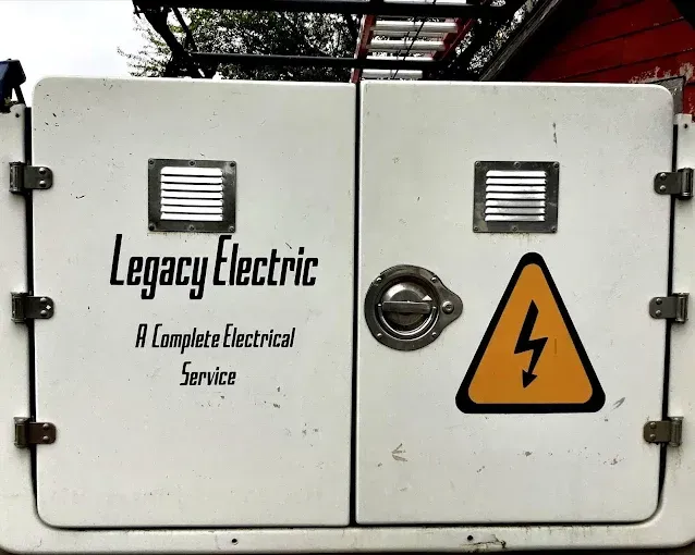 White electrical cabinet with Legacy Electric logo, warning sign.