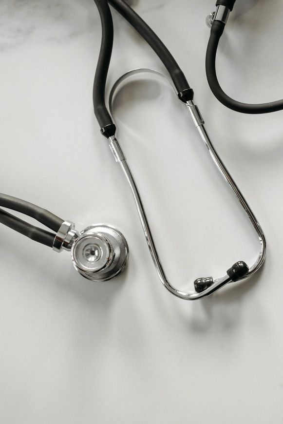 Black stethoscope with silver chest piece on a white surface