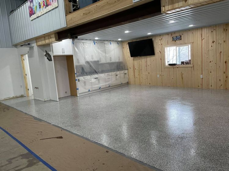 Empty indoor hall with a polished gray floor, wood-paneled wall, and a small window.