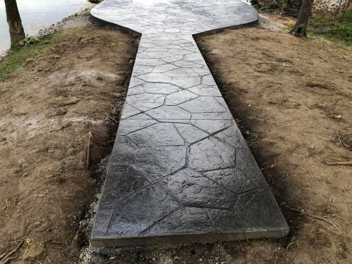 Concrete path with a T-shaped junction through a dirt outdoor area, seen from above.