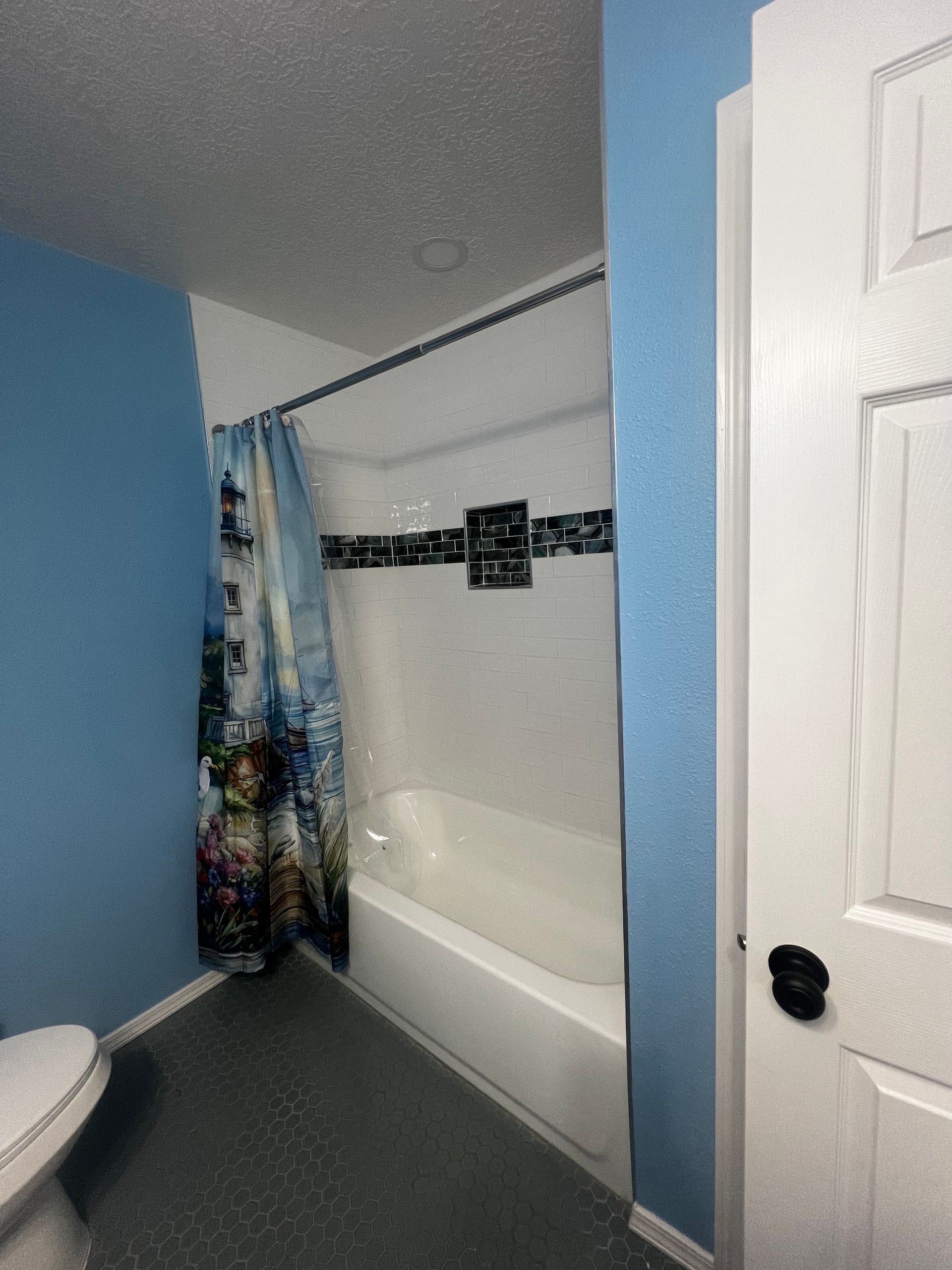 Bathroom with brown walls, sink, toilet, towels, and decorative artwork.