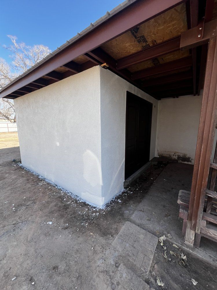 Concrete foundation under construction, with rebar grid and wooden framing on dirt.
