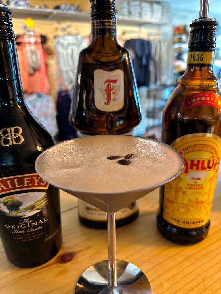 Martini with coffee beans, surrounded by Baileys, Frangelico, and Kahlua bottles.