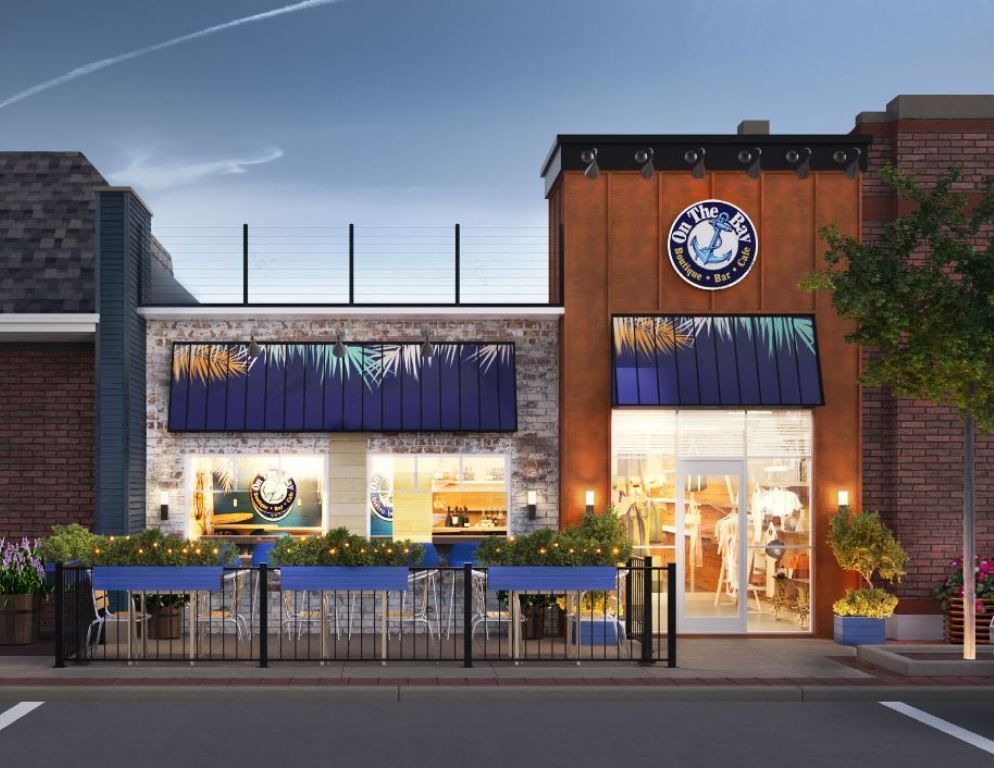 Restaurant facade with blue accents, outdoor seating, and a neon sign at dusk.