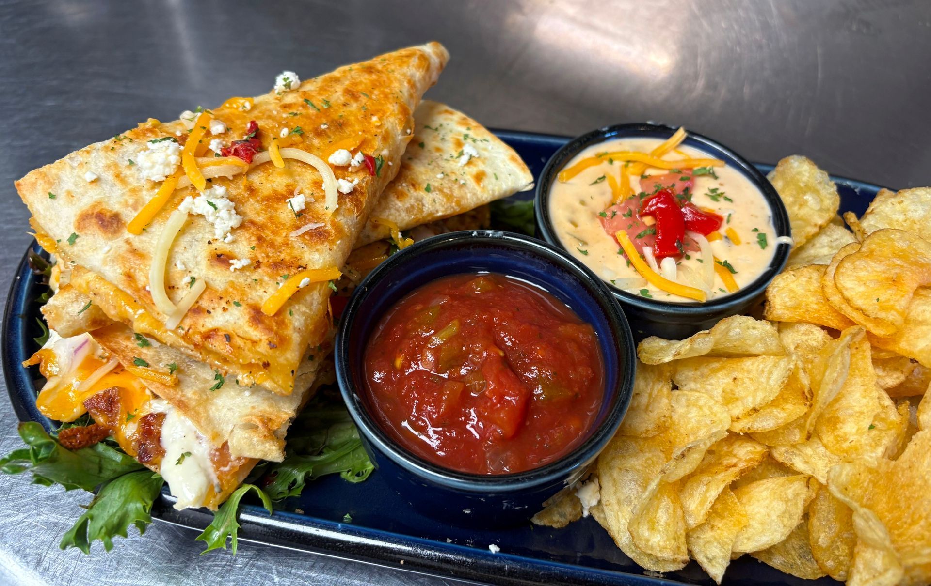 Our Quesadilla is stuffed with chicken, cheese and served with chips at On The Bay Restaurant