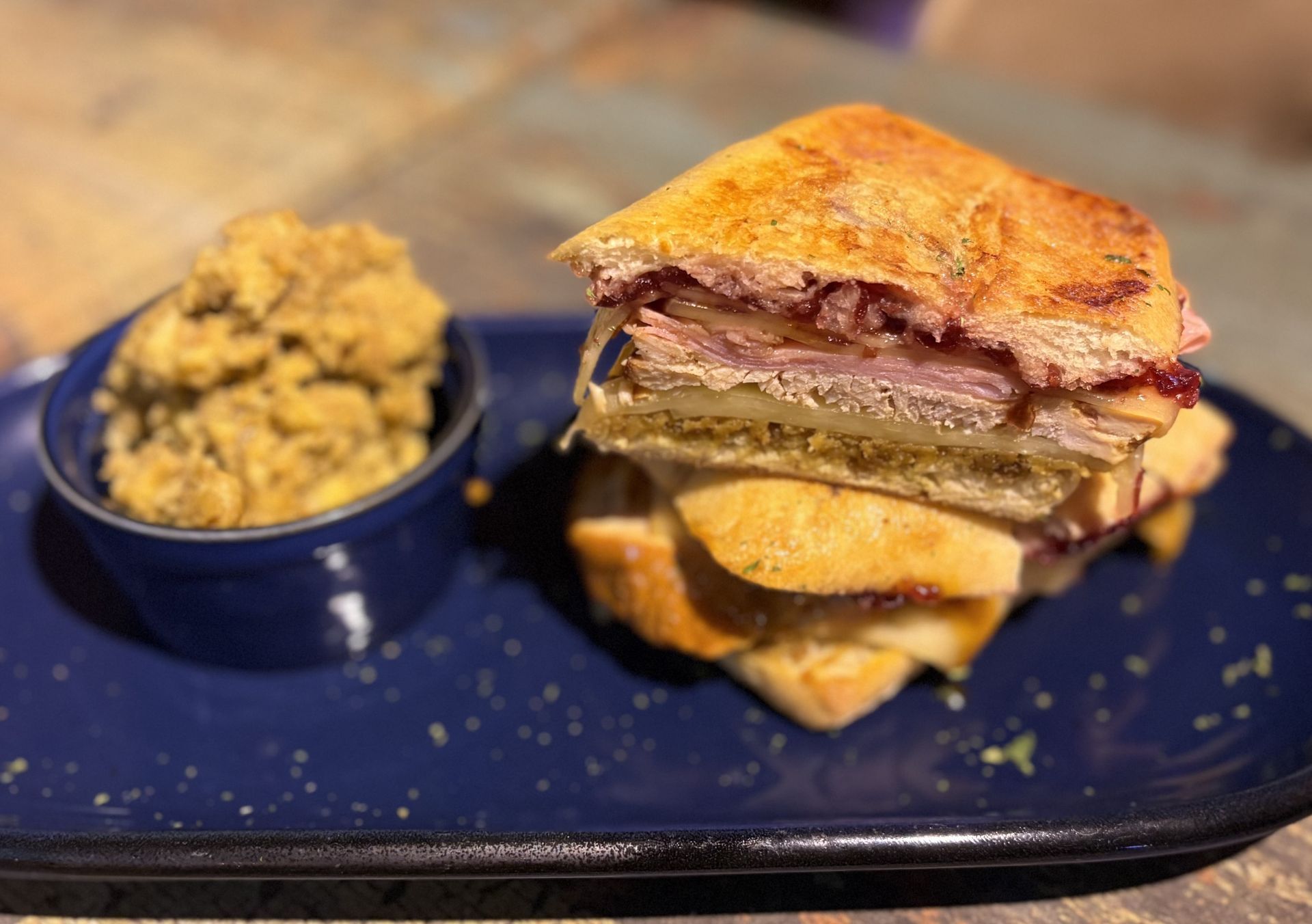 Cuban sandwich with stuffing on a blue plate.