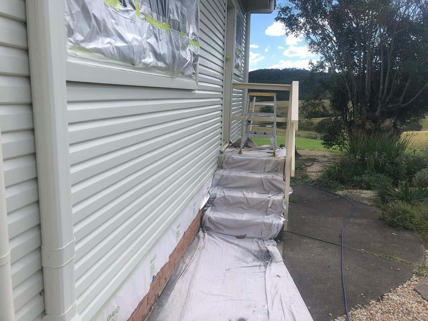 A White House With Stairs Covered in Plastic and a Tree in the Background — The Big Bearded Painter In Medowie, NSW