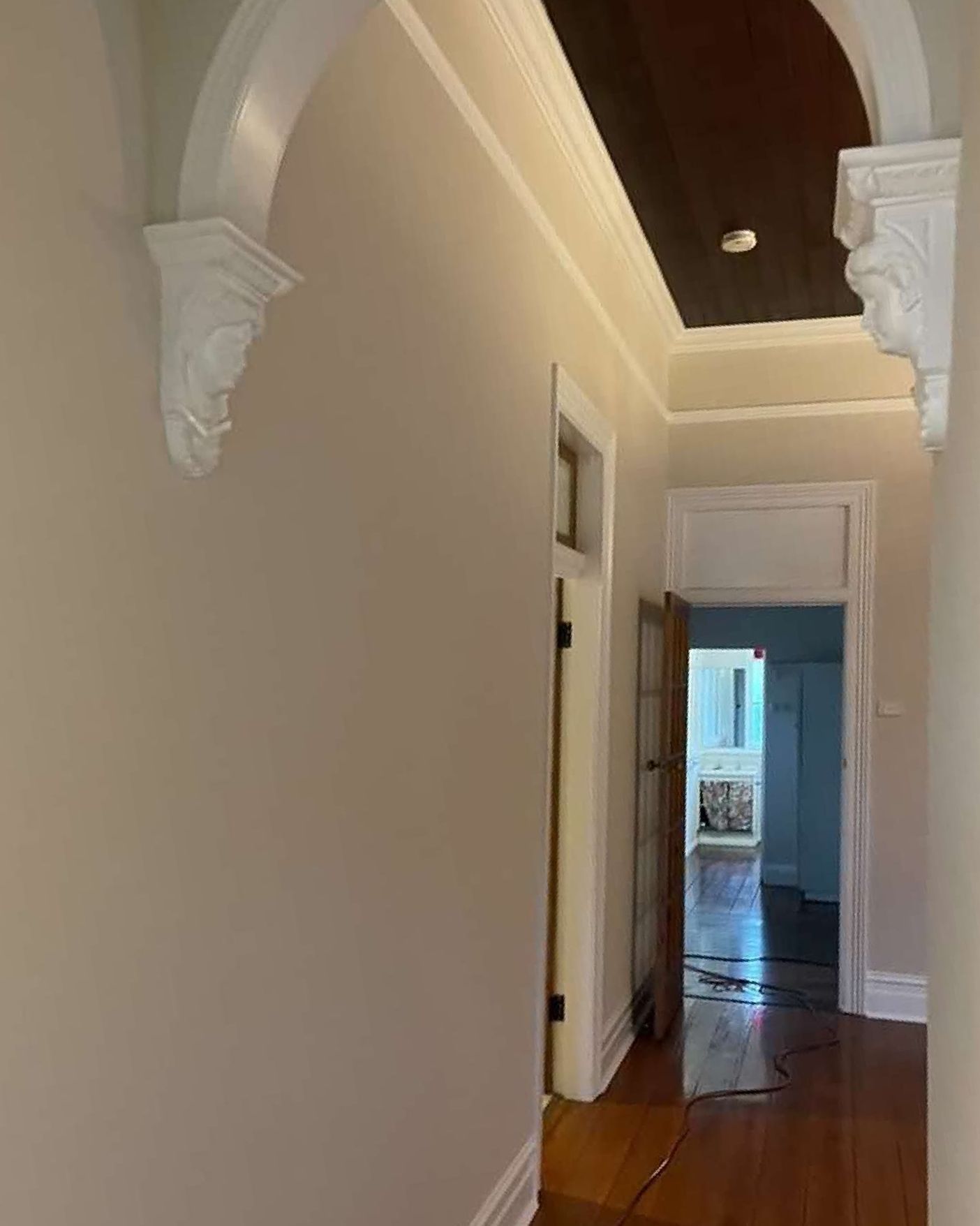 A Hallway With a Wooden Floor and a White Archway Leading to a Room — The Big Bearded Painter In Booral, NSW