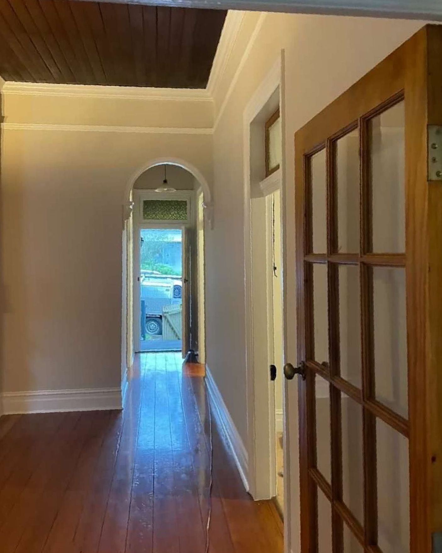 A Long Hallway With Hardwood Floors and a Wooden Door Leading to a Living Room — The Big Bearded Painter In Kurri Kurri, NSW
