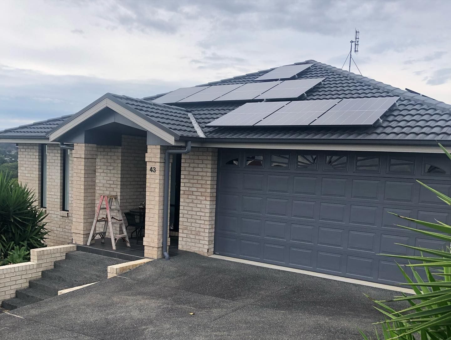 A House With a Garage Door and Solar Panels on the Roof — The Big Bearded Painter In Maitland, NSW