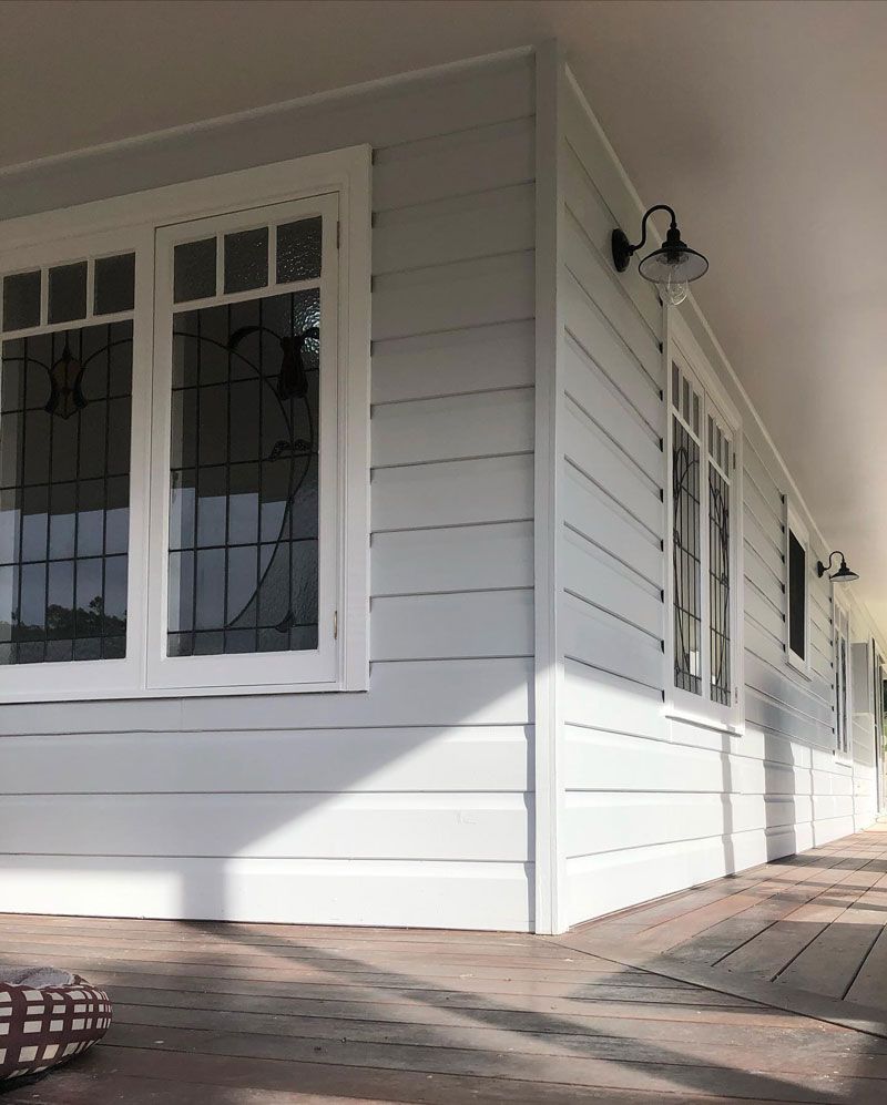 A White House With Stained Glass Windows and a Porch 