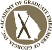 Round seal logo for the Academy of Graduate Management Studies with crossed tools and gold border